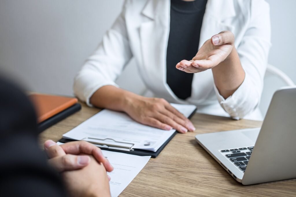 Employer or recruiter holding reading a resume with talking during about his profile of candidate